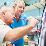 Arteterapeuta prowadzący terapię przez sztukę z osobą dorosłą