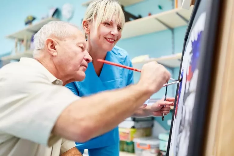 Arteterapeuta prowadzący terapię przez sztukę z osobą dorosłą