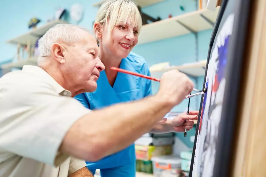 Arteterapeuta prowadzący terapię przez sztukę z osobą dorosłą